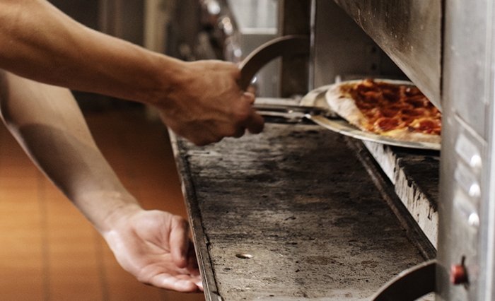 pizza going into oven